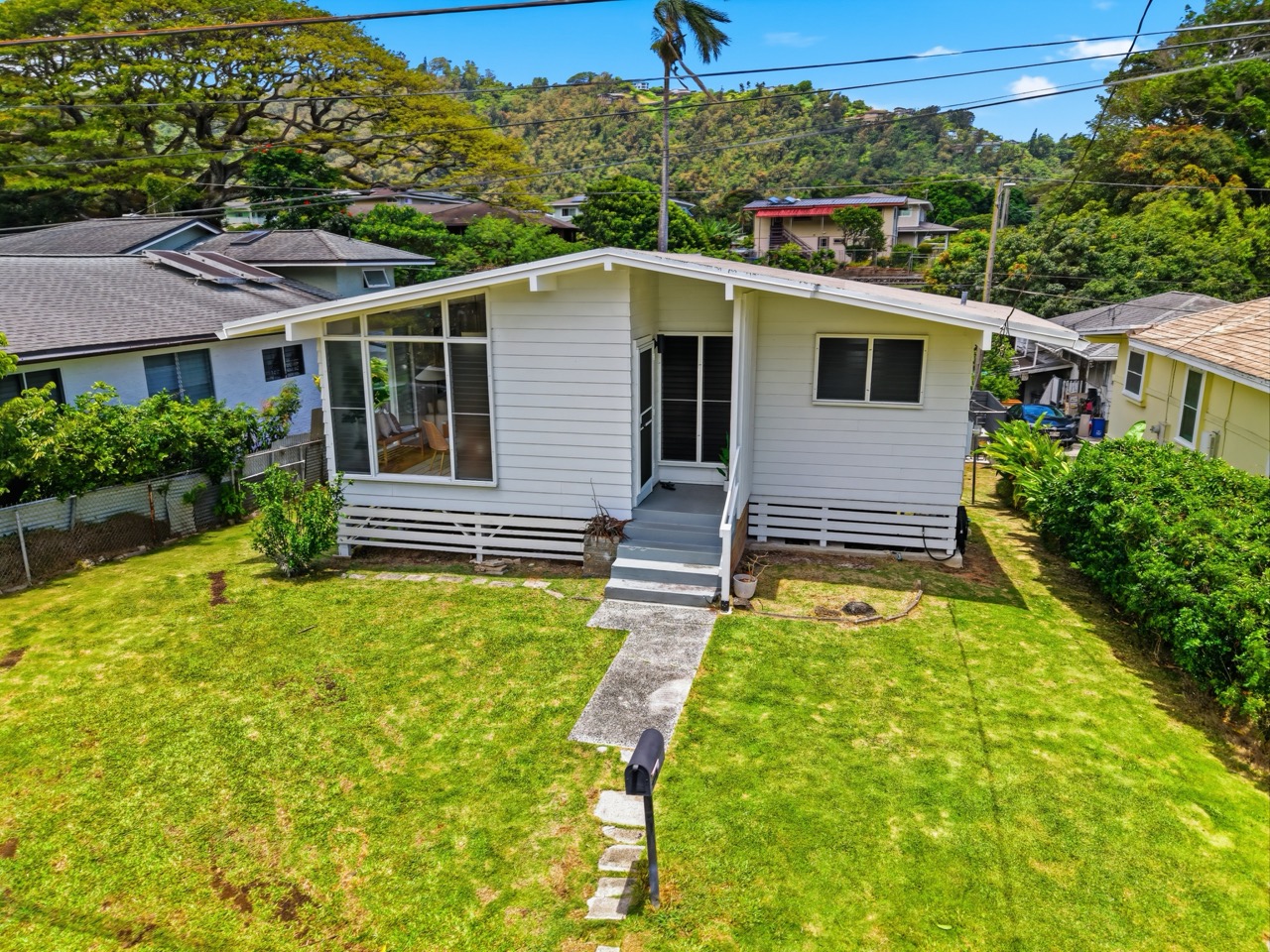 Rear of home with grassy backyard and mountain views