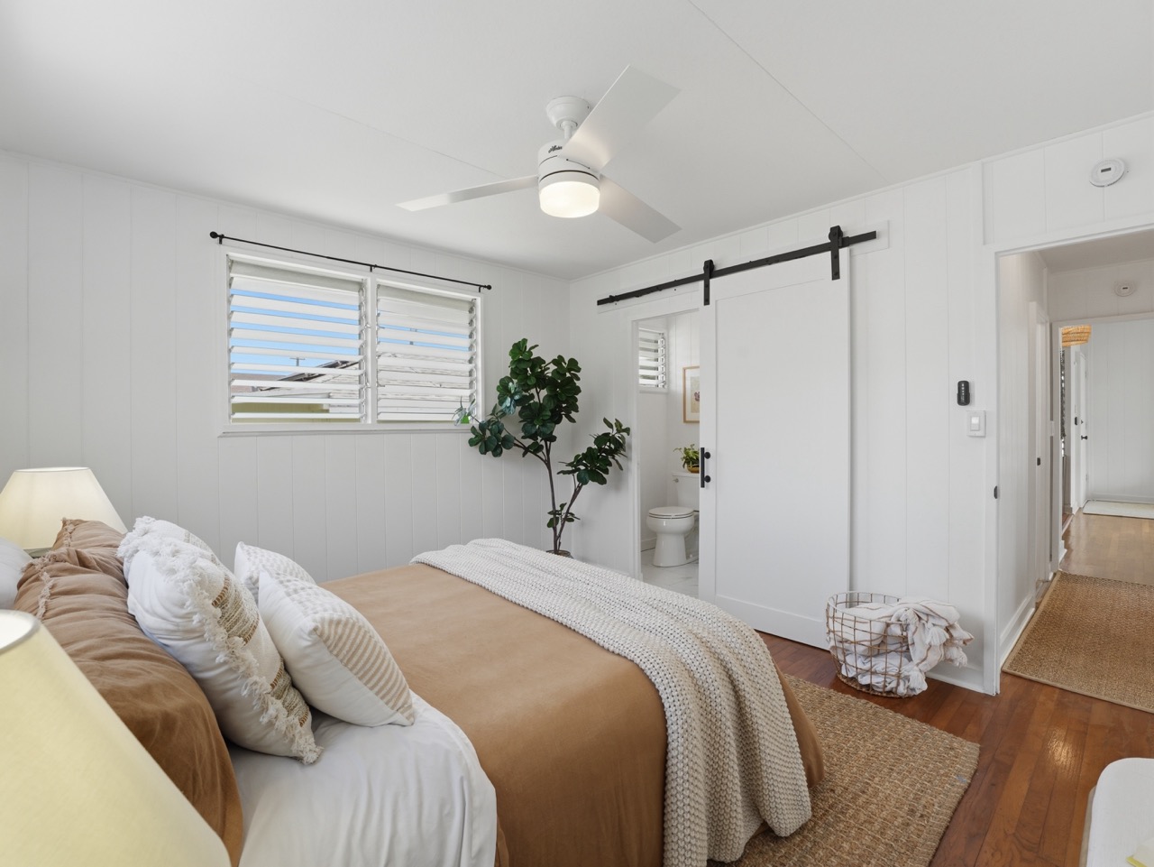 Bedroom with barn door leading to ensuite bath