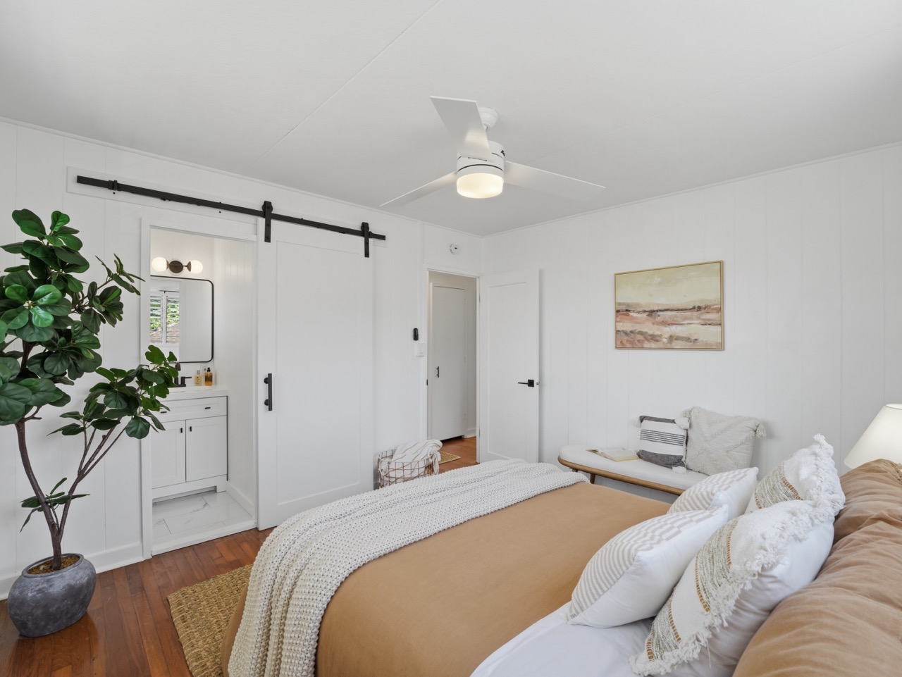 Bedroom with view into adjoining bath through barn door