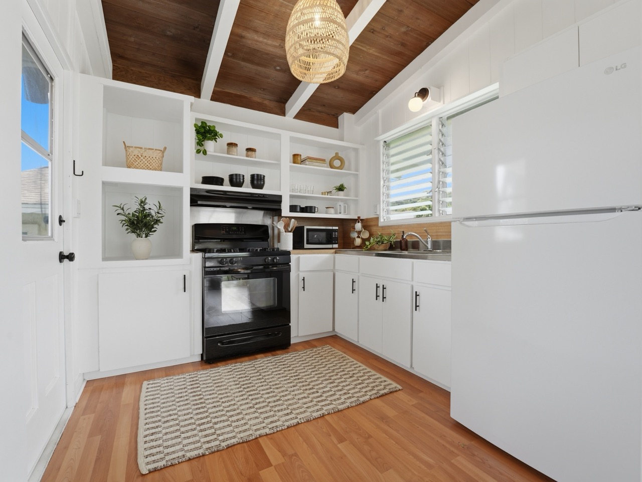 Compact white kitchen with gas range and refrigerator