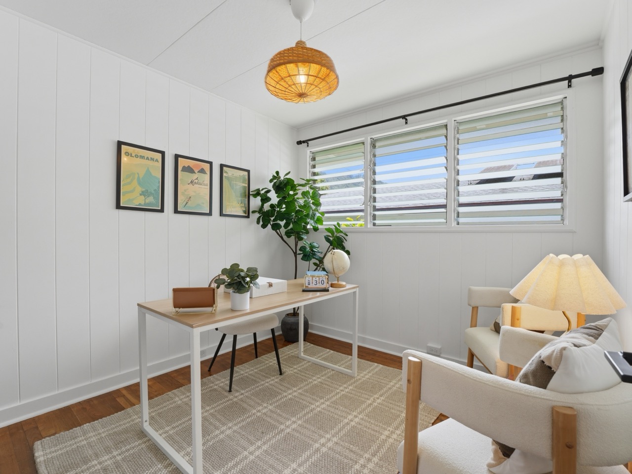 Home office with desk, framed Hawaii prints and rattan pendant